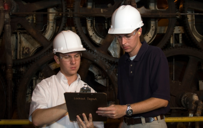 Lockout Tagout - OSHA 1910.147 - Men reviewing safety protocol by a machine