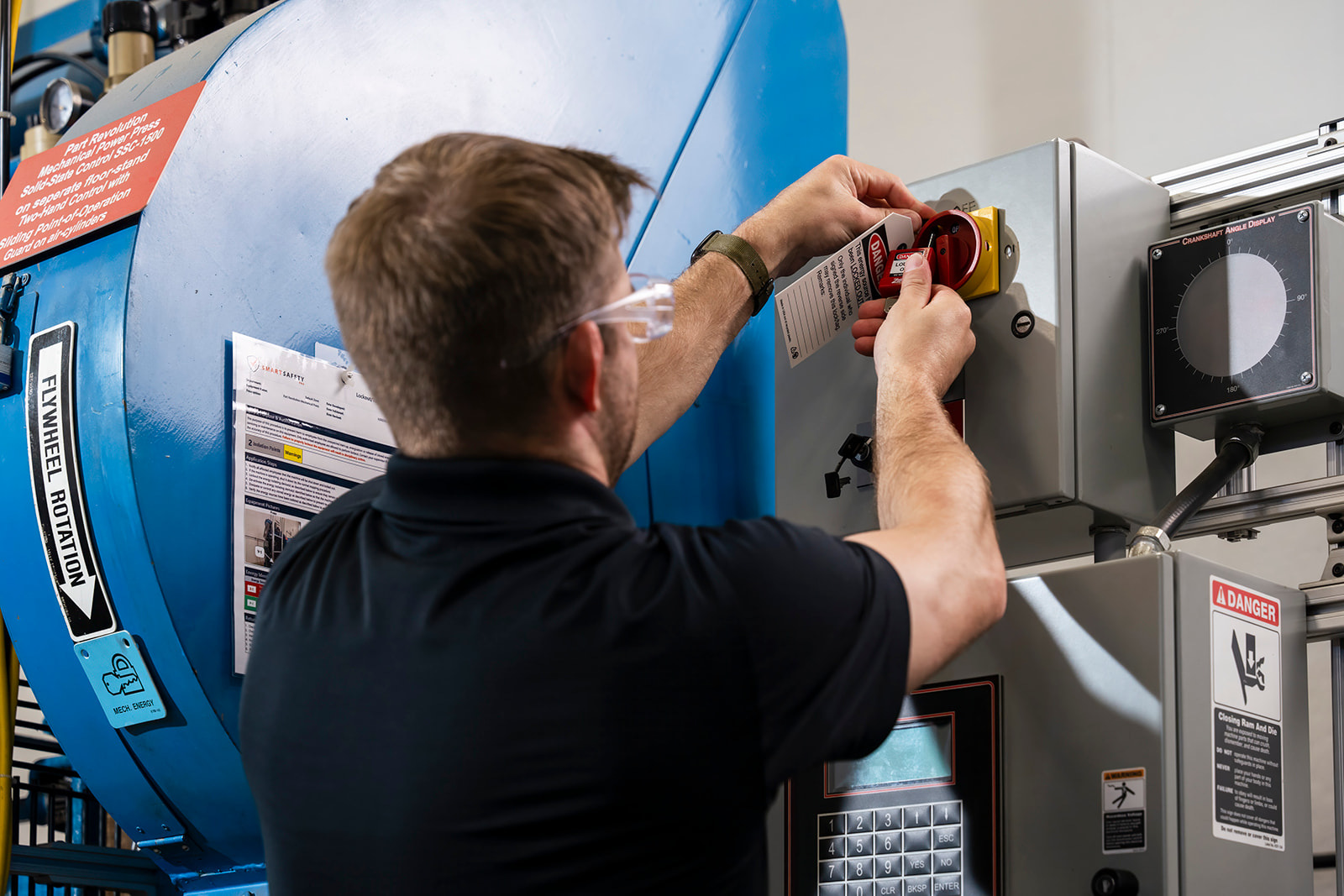 lockout tagout roles - man performing a lockout tagout on a machine